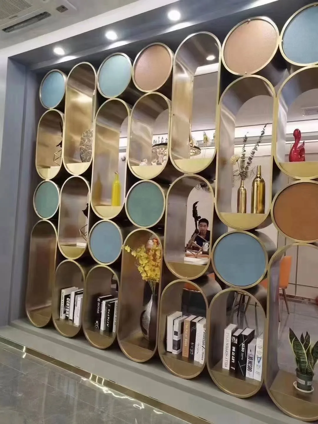 Sculptural gold-tone metal display divider with oval niches and circular panels