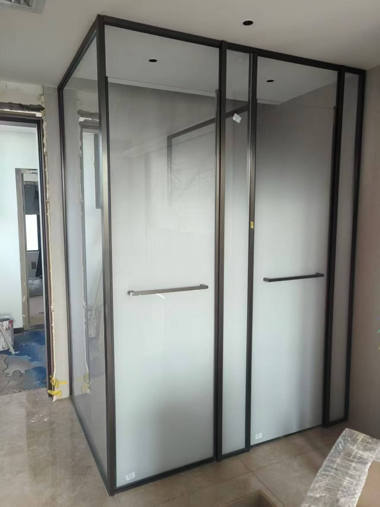 采用纤细黑色金属框架的通高磨砂玻璃隔断系统